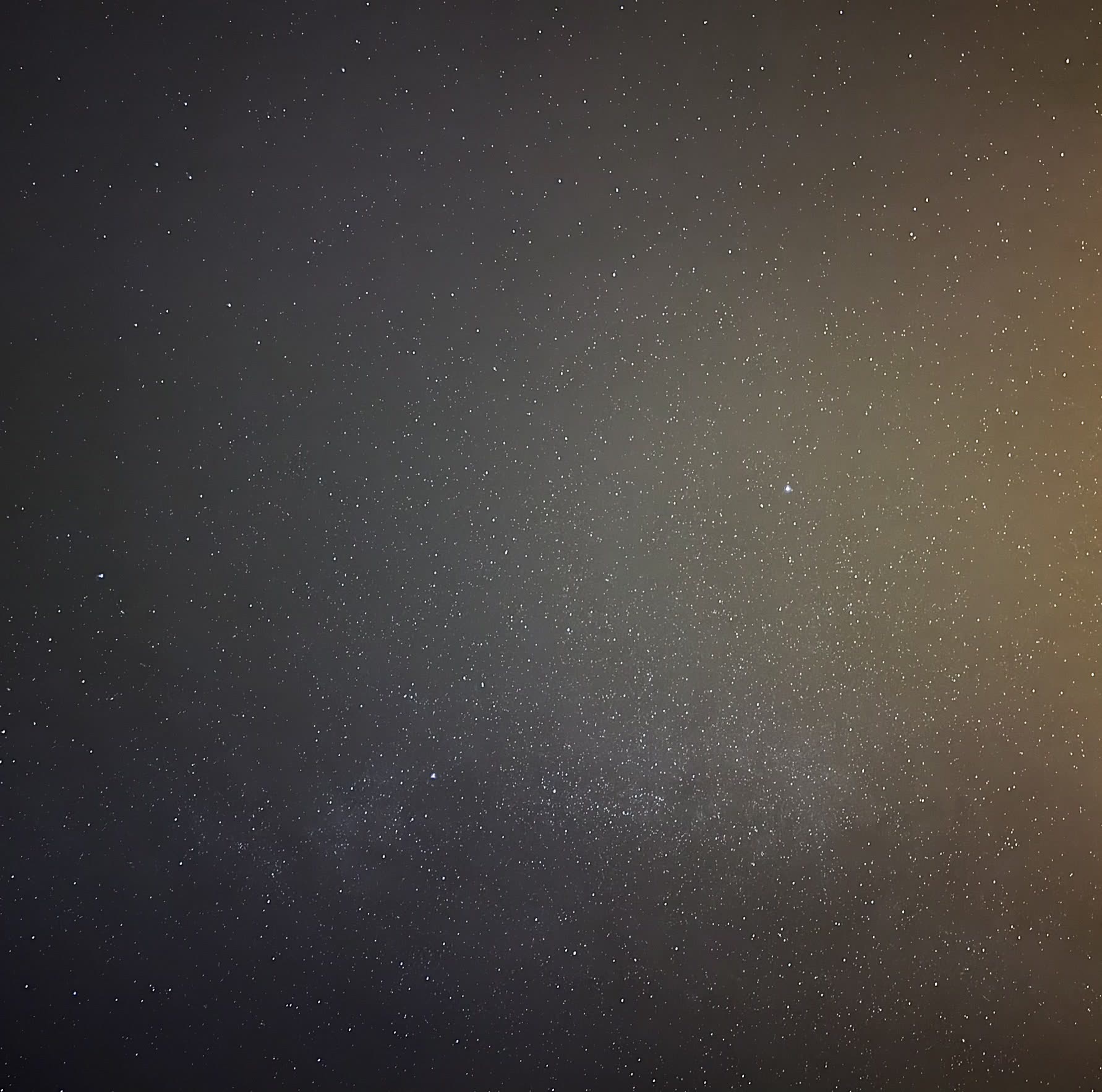 Un ciel de nuit dense, traversé d'une traînée d'étoiles.