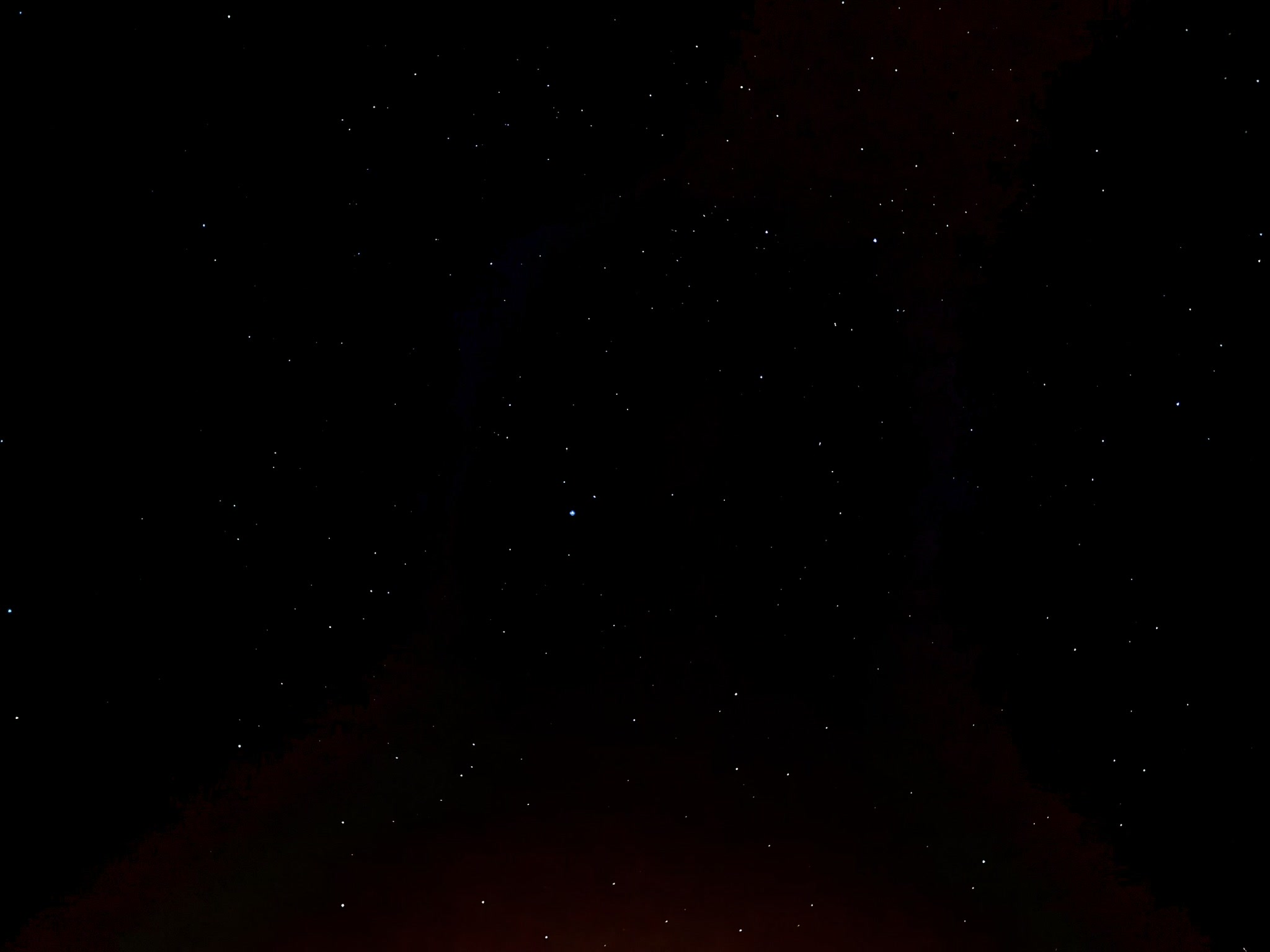 Des étoiles au-dessus d'un horizon rougeoyant.