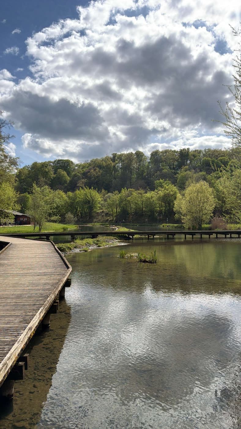 Un ponton de bois au bord d'un lac, sous un ciel nuageux.