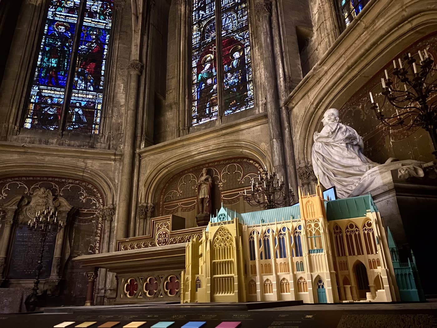 L'intérieur d'une cathédrale, avec une maquette sculptée au premier plan.